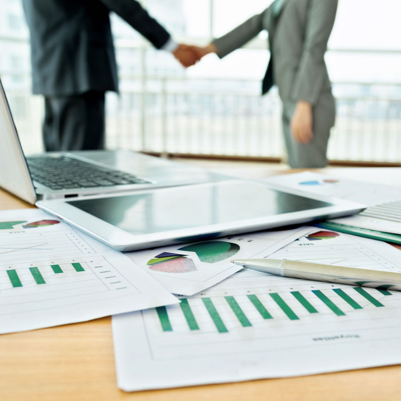 Men shaking hands at an office after making a deal